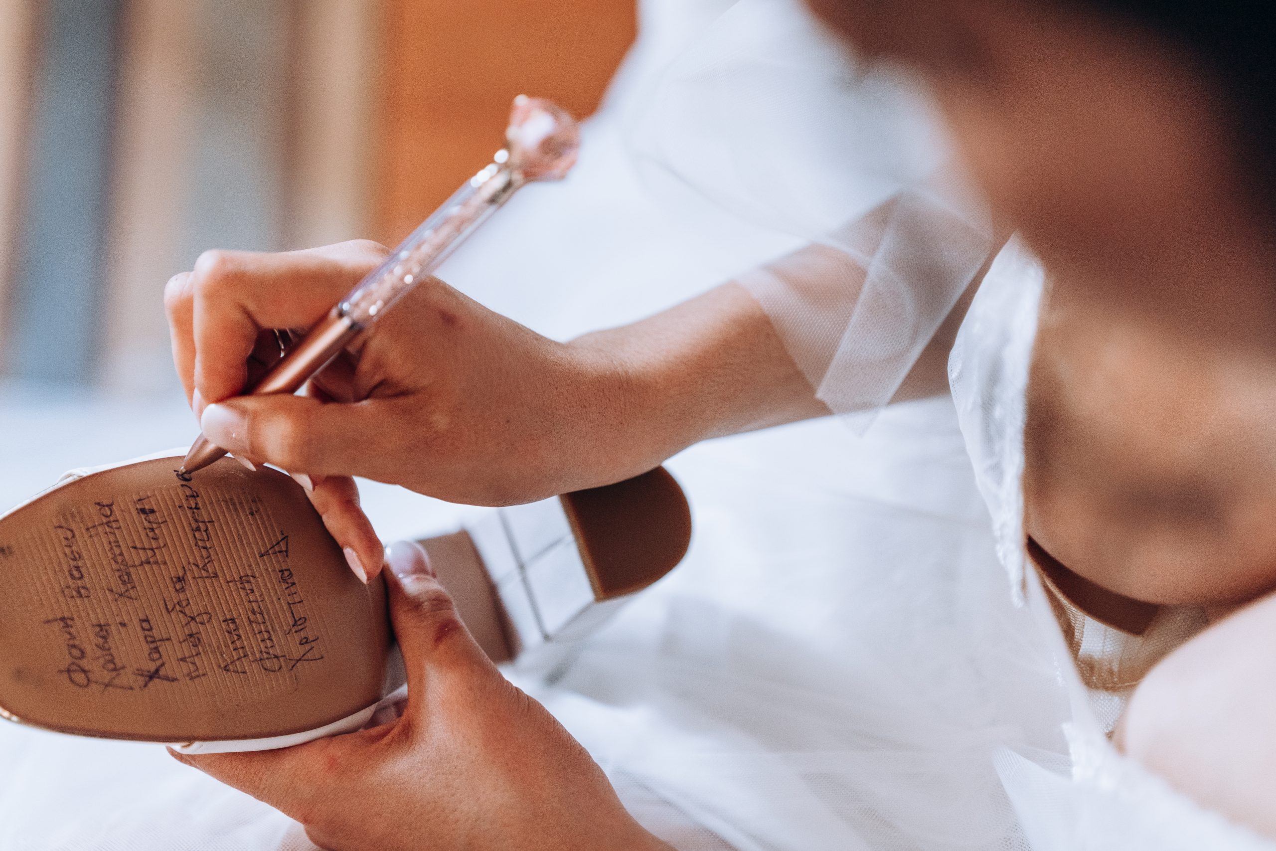 bride writing friends names on the bottom of her wedding shoes for good luck at a toronto wedding