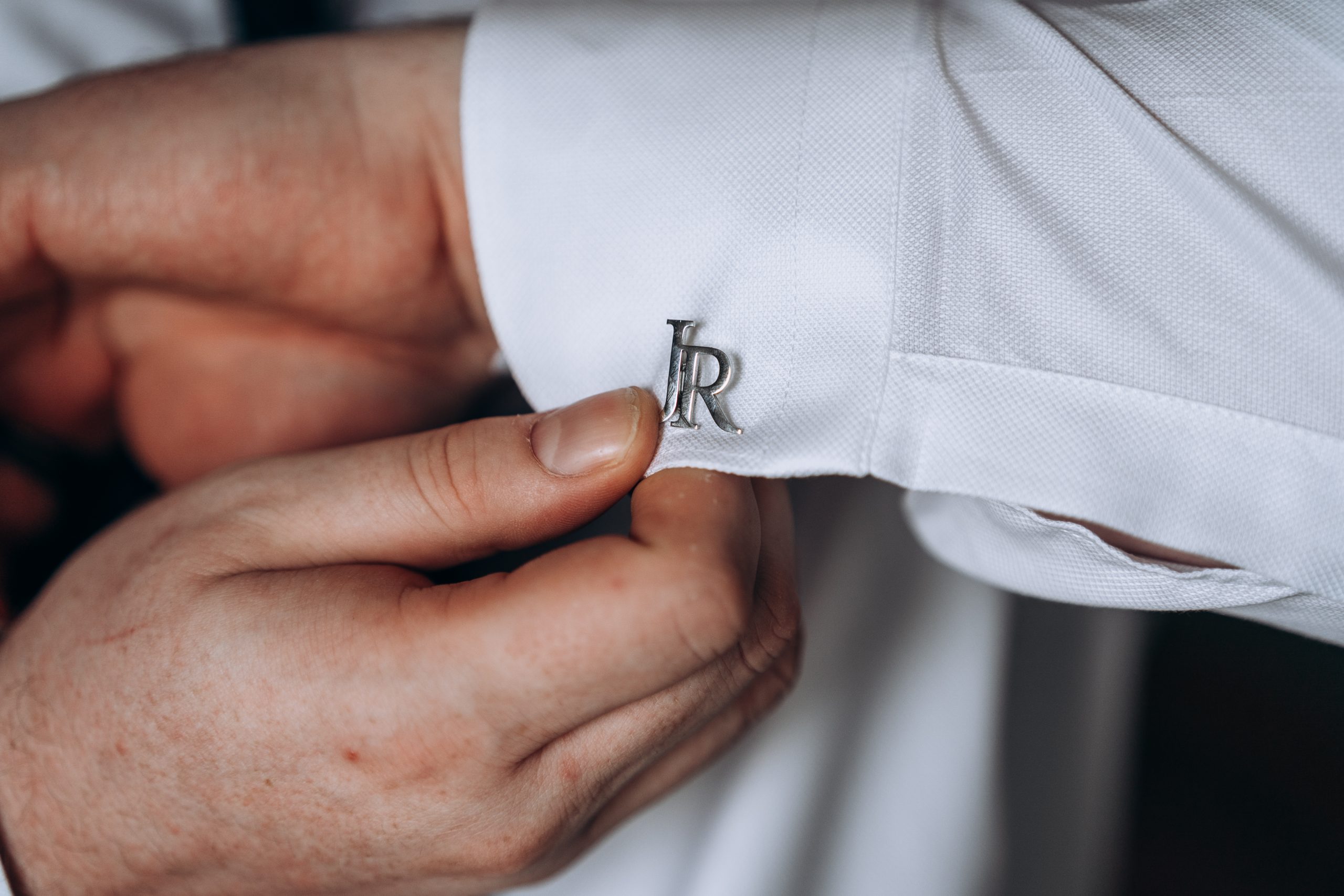 detail image of grooms cufflink as her prepares for his wedding day