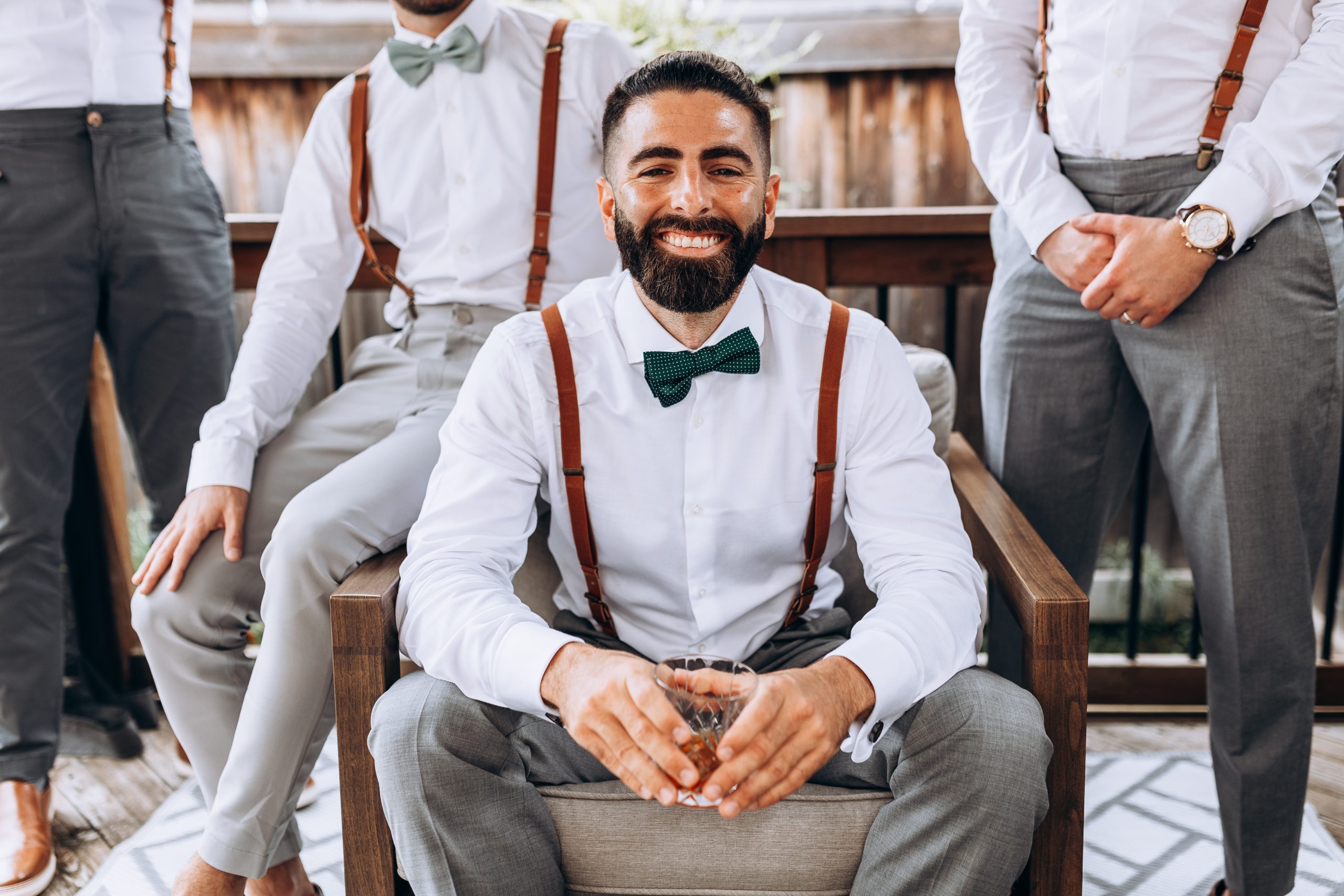 room is all smiles as his groomsmen stand behind him