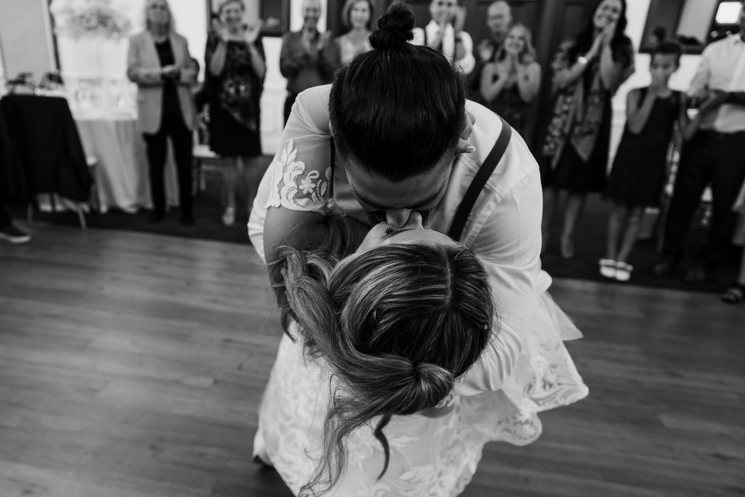 groom dips the bride on the dance floor during their wedding reception