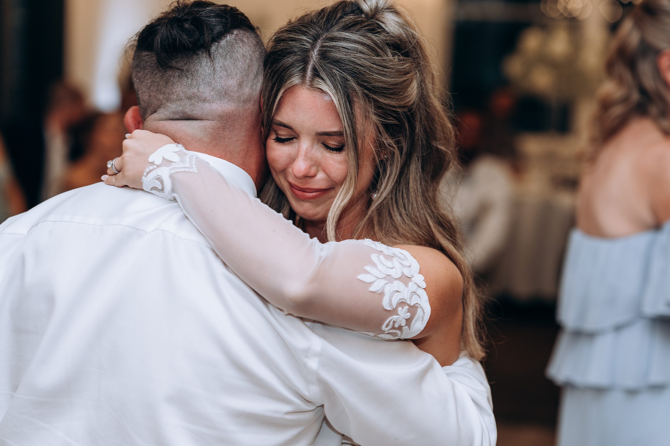 bride sheds a tear as she dances with her father during the wedding reception