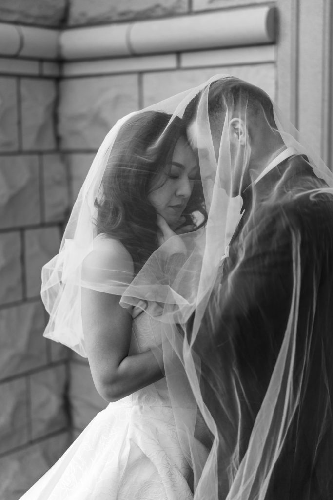 bride and groom embrace under her veil
