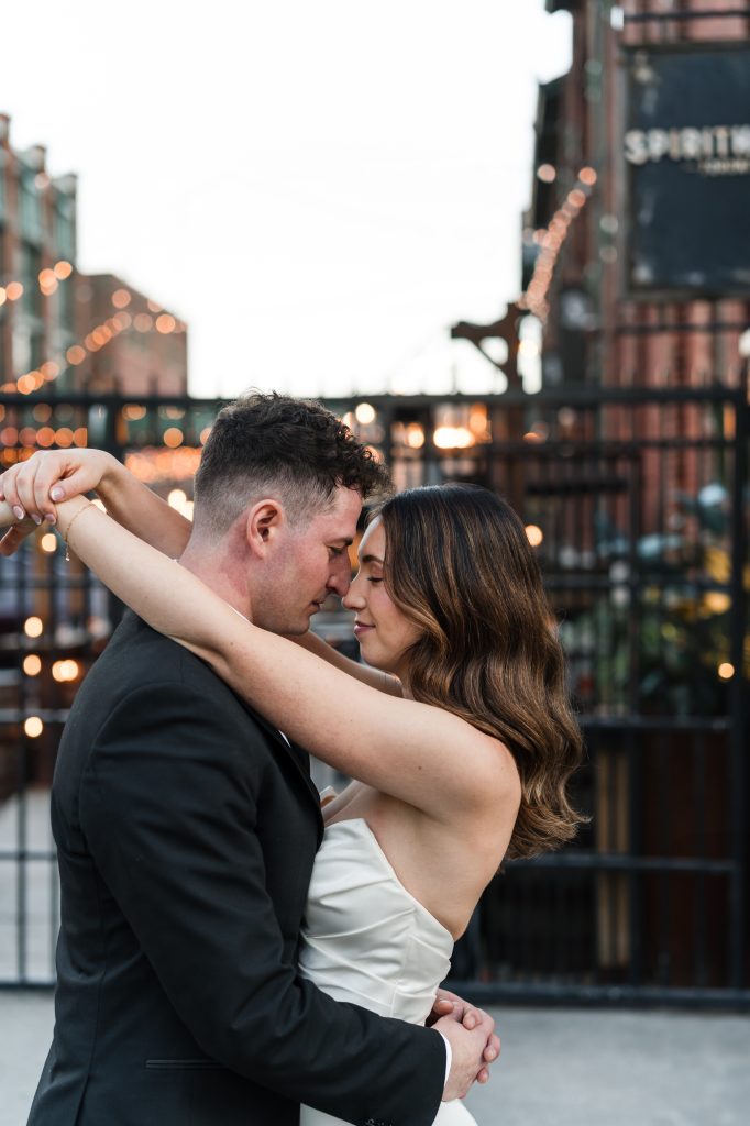 the bride and groom embrace for a photo at the distillery district in toronto